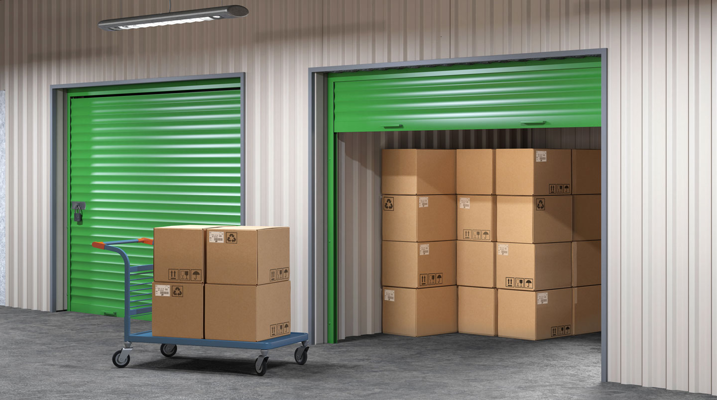 Femme organisant des cartons étiquetés et du mobilier protégé dans un box de stockage de 10 mètres carrés
